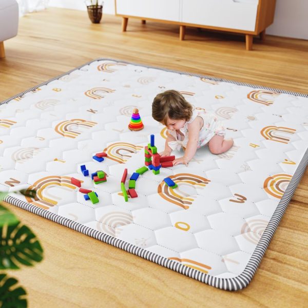 baby playing on rainbow baby floor mat